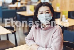 Asian girl in a protective mask is sitting in a school Product Image 1