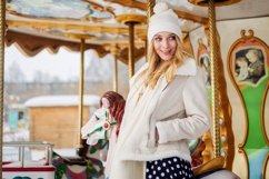 Smiling blonde lady stands on a merry-go-round Product Image 2