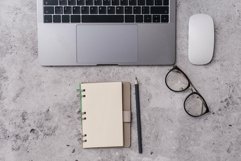 An empty notebook with a pencil sits on top of a office desk Product Image 1