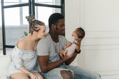 Husband and wife happily look at their monthly baby. Product Image 1