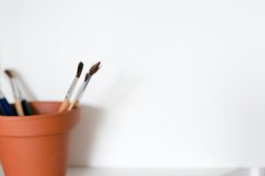 A pot of artists paint brushes in a browm pot on a white Product Image 1