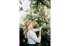 Beautiful young blonde girl in blooming Apple orchard. Product Image 1