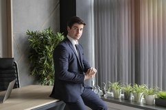 portrait of a businessman in a dark blue suit in the office Product Image 1