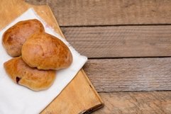 Russian pirozhki baked patties with berries on wood Product Image 1