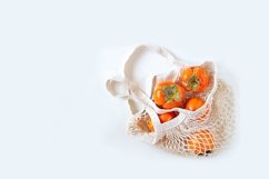 Persimmon in a mesh bag. Product Image 1