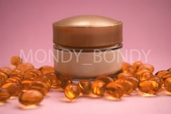 Bottle of cream with oil capsules on a pink background. Product Image 1