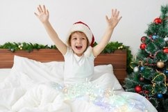 Happy funny girl haning fun on the bed on Christmas morning Product Image 1