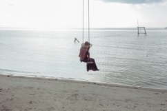 Woman enjoying summer holiday on beach with swing Product Image 1