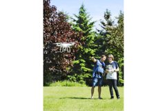 Father and son on summer day flying drone on countryside. Product Image 1