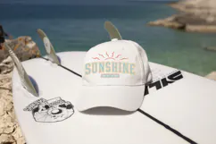 Summer-themed graphic with large block letters spelling sunshine and small banner text below, accented with sun rays for a warm weather aesthetic