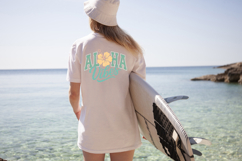 Island-style graphic with layered text reading Aloha Vibes, featuring a tropical flower centerpiece and subtle worn texture for a relaxed beach aesthetic