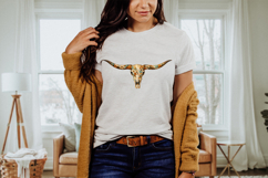 Rustic boho cow skull graphic with floral painted design covering the bone surface and horns, symmetrical longhorn skull artwork perfect for western themed sublimation printing and DIY crafts.