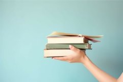 Hand holding stack of books. Generate ai Product Image 1