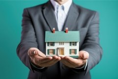 Real estate agent holding big new house model. Generate Ai Product Image 1