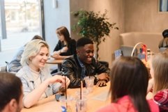 Multinational friends laugh together in a coffee shop Product Image 1