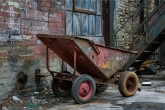 Old rusty wheelbarrow standing in abandoned factory Product Image 1