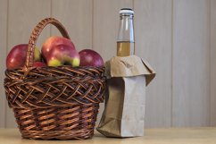 Glass bottle with a cider and apples in the basket Product Image 1