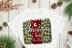christmas sublimation designon a squared green and red background with a phrase Christmas is here on a white  T-shirt