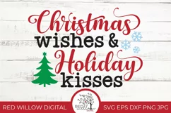 Christmas saying displayed in red black and green with snowflakes and a Christmas tree. It is displayed on a plain wood background.