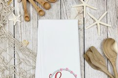 Circle of love embroidery design shown on white tea towel. This is a inspiration photo showing how this embroidery pattern can be used.
