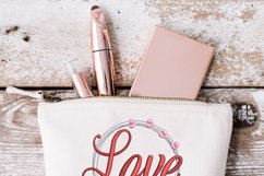 Circle of love embroidery design shown on cream cosmetic bag. This is a inspiration photo showing how this embroidery pattern can be used.