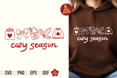 Cozy Season SVG PNG design with aesthetic line art doodles of a candle, bow, latte, leaf, and sweater on a brown hoodie mockup