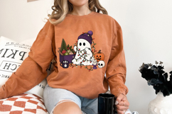 Spooky holiday sublimation design combining Halloween and Christmas elements with a ghost, pumpkin, skull, candle, ornaments, and Christmas tree.