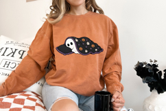 PNG only Halloween design with a cozy ghost, pumpkin and ghost pattern blanket, purple trim, and playful spooky style.