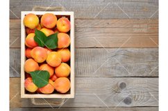 Apricots in box on wooden table Product Image 1