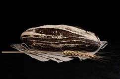 Homemade sourdough rye bread and spikelet on black Product Image 1