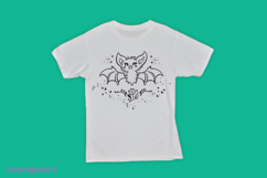 A cute, cartoon-style bat design is printed on a white t-shirt. The bat has fluffy fur, large wings, and an adorable expression, surrounded by stars, hearts, and flowers. The design is in black ink, creating a playful and whimsical look against the white 