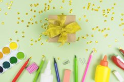 Gift with golden bow and confetti with school stationery Product Image 1