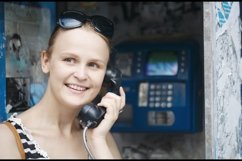 Attractive woman using a public telephone Product Image 1