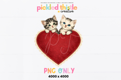 Vintage-inspired kitten illustration showing two cats leaning over a lace-edged heart with soft texture and classic Valentine charm.