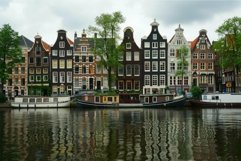 Traditional dutch houses reflecting in the canal on a cloudy Product Image 1