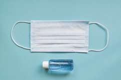 medical mask and sanitizer on blue background. Product Image 1
