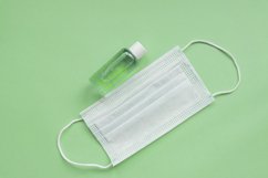 medical mask and sanitizer on green background Product Image 1