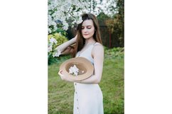 Beautiful young girl in hat in blooming Apple orchard. Product Image 1