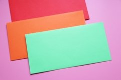 envelopes of different colors on a pink background. Product Image 1