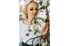 Beautiful young blonde girl in blooming Apple orchard. Product Image 1