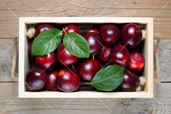 Plums in wooden box close-up Product Image 1