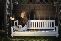 Pretty brunette in black hoodie sitting on swing Product Image 1