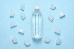 Water bottle and ice pieces on blue table top view Product Image 1