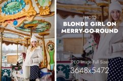Smiling blonde lady stands on a merry-go-round Product Image 1