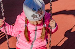 Little girl 5-6 years on a playground swinging on swing. Product Image 1