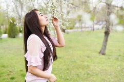 Spring background happy young woman enjoying smell Product Image 1