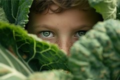 Eyes of innocence: child peering through green leaves Product Image 1