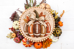 Autumn sports PNG design showing a pumpkin made from footballs with white stitching, warm fall colors, leafy accents, and a burlap-style bow.