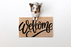 Large script welcome design with a sweeping underline and modern calligraphy style, shown against a light wood backdrop. Clean vector-style lines make it perfect for cutting machines and sign crafting.