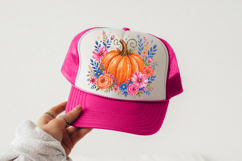 Rustic watercolor pumpkin with pink cosmos-style blooms, peach roses, and blue wildflowers arranged in a balanced floral wreath.